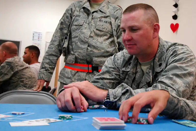 A player sitting at a card table carefully stacking casino chips