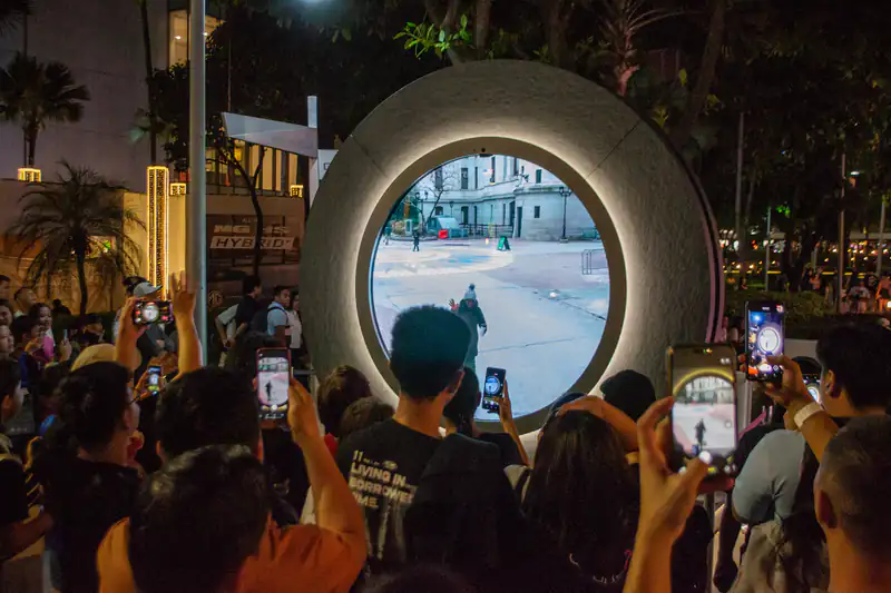 People gathered at night in Manila filming with their smartphones
