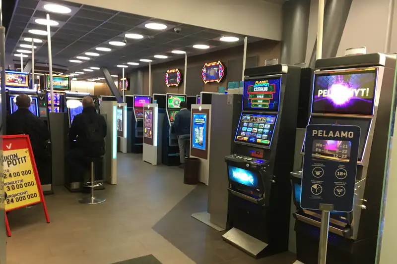 Rows of brightly lit slot machines in a casino gaming room